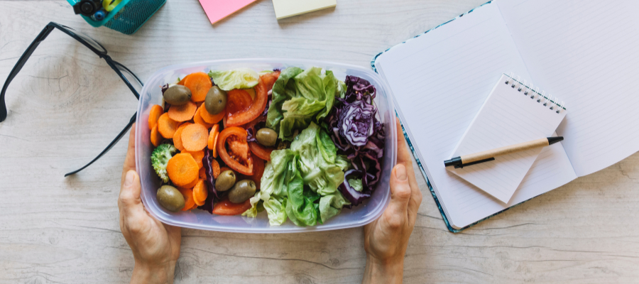 tupperware com hortícolas em cima de uma mesa