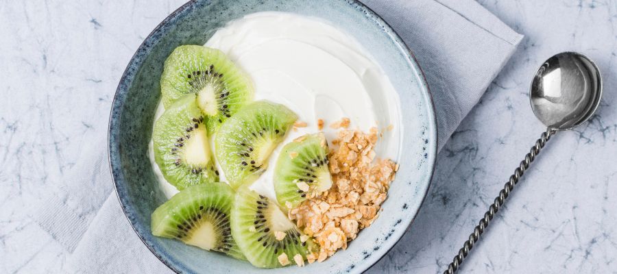 tigela de pequeno-almoço com iogurte, aveia e kiwi