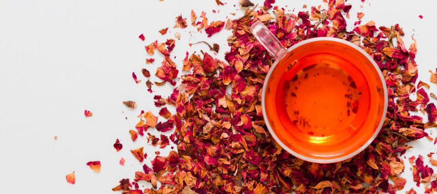 Chávena de chá de rooibos vista de cima com o chá seco à sua volta