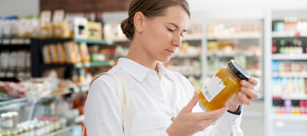 Senhora num supermercado a ler um rótulo alimentar