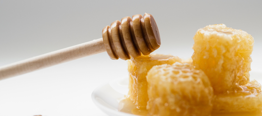 Pedaços de favos de mel com colher em madeira