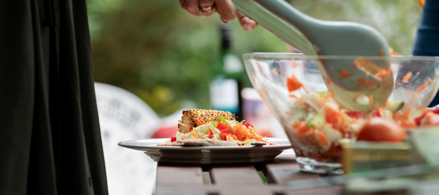 Mulher a servir uma salada fresca como jantar leve