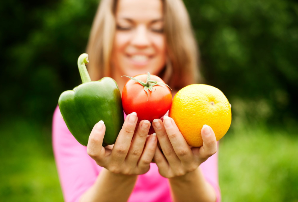 Mulher jovem a segurar frutas e legumes