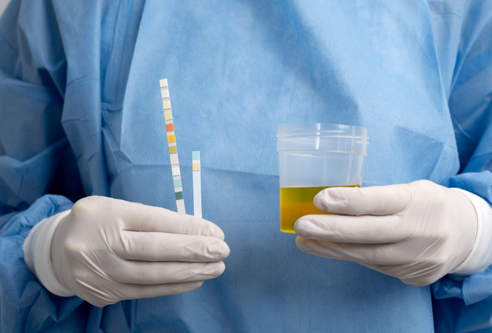Médico com frasco na mão a realizar exame de urina